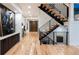 Bright entryway featuring hardwood floors, modern staircase with metal railings, and a designer front door at 2495 Red Hawk Pl, Broomfield, CO 80023