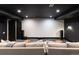 Spacious home theater with projector screen, plush seating, and modern black and white design at 2495 Red Hawk Pl, Broomfield, CO 80023
