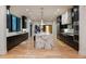 A modern kitchen features black cabinets, hardwood flooring, a waterfall island, and stainless steel appliances at 2495 Red Hawk Pl, Broomfield, CO 80023