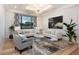 Bright and airy living room featuring hardwood floors, stylish furniture, and a large window with a backyard view at 2495 Red Hawk Pl, Broomfield, CO 80023