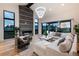 Bright living room with a stone fireplace, hardwood floors, stylish furniture, and large windows offering natural light at 2495 Red Hawk Pl, Broomfield, CO 80023