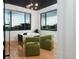 Modern office with a black ceiling, sleek desk, two green chairs, and large windows overlooking the property at 2495 Red Hawk Pl, Broomfield, CO 80023