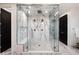 Spacious glass-enclosed shower with dual showerheads, bench, and modern tiling for a spa-like experience at 2495 Red Hawk Pl, Broomfield, CO 80023