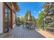 Back deck features metal railing, an outdoor dining set, and natural landscaping at 6663 S Prescott Way, Littleton, CO 80120