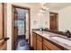 Double sink bathroom with wooden floors, dark wooden doors, and good lighting at 6663 S Prescott Way, Littleton, CO 80120