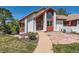 Inviting front entrance featuring colorful landscaping, a unique walkway, and a white facade with wooden accents at 6663 S Prescott Way, Littleton, CO 80120