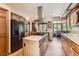 Open kitchen featuring wood cabinets, stainless steel appliances, a spacious island, and an eat-in dining area at 6663 S Prescott Way, Littleton, CO 80120
