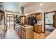 Spacious kitchen with stainless steel appliances, wood cabinets, and a center island with a range top at 6663 S Prescott Way, Littleton, CO 80120