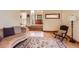 Welcoming living area featuring hardwood floors, an ornate rug, a leather accent chair, and wood trim at 6663 S Prescott Way, Littleton, CO 80120