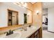 Bathroom featuring dual sinks, wood paneled walls, and a spacious closet at 1579 W Briarwood Ave, Littleton, CO 80120