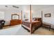 Comfortable bedroom featuring a four-poster bed, dresser with mirror and a neutral color palette at 1579 W Briarwood Ave, Littleton, CO 80120