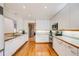 Spacious kitchen featuring white cabinetry, stone accents, hardwood floors and modern stainless steel appliances at 1579 W Briarwood Ave, Littleton, CO 80120