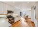 Bright kitchen features white cabinets, hardwood floors, stainless steel appliances and an eat-in dining nook at 1579 W Briarwood Ave, Littleton, CO 80120
