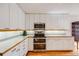 Bright kitchen offers white cabinets, stainless appliances, wooden floors and ample counter space at 1579 W Briarwood Ave, Littleton, CO 80120