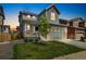 Charming two-story home with a manicured lawn, gray siding, and a welcoming front porch at 10983 Uvalda St, Commerce City, CO 80022
