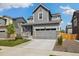 Attractive two-story home with gray siding, a two-car garage and well-kept landscaping at 10983 Uvalda St, Commerce City, CO 80022
