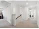 Bright hallway with neutral carpet and white walls that leads into various rooms of the house at 10983 Uvalda St, Commerce City, CO 80022