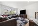 Spacious living room with modern furniture, including a plush sofa and large television at 10983 Uvalda St, Commerce City, CO 80022