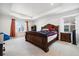 Elegant main bedroom with tray ceiling, large bed, and neutral carpet at 10983 Uvalda St, Commerce City, CO 80022