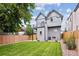 Backyard featuring a lush lawn, a modern grey house, and a wooden fence at 3908 Mariposa St, Denver, CO 80211