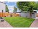 A large well-maintained backyard, featuring a wood fence, a large tree, and stone landscaping at 3908 Mariposa St, Denver, CO 80211