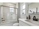 Modern bathroom with marble-look shower, glass door, sleek white vanity, and a large window at 3908 Mariposa St, Denver, CO 80211