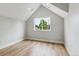 Cozy bedroom featuring vaulted ceilings, hardwood floors, and a large window with neighborhood views at 3908 Mariposa St, Denver, CO 80211