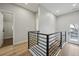 Bright hallway with hardwood floors, a modern black railing, and white walls leading to other rooms at 3908 Mariposa St, Denver, CO 80211