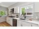 Bright kitchen boasts white cabinets, stainless steel appliances, and subway tile backsplash at 3908 Mariposa St, Denver, CO 80211