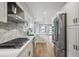A modern kitchen boasts white cabinetry, stainless steel appliances, hardwood flooring and plenty of counter space at 3908 Mariposa St, Denver, CO 80211