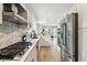 Modern kitchen with stainless steel appliances, white cabinetry, and a view to the dining area at 3908 Mariposa St, Denver, CO 80211