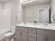 Modern bathroom with a double vanity, white countertops, and a tiled bathtub with shower at 12283 W 57Th Ln, Arvada, CO 80002