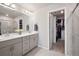 Bathroom featuring dual sinks, walk in shower, and a view to a closet at 12283 W 57Th Ln, Arvada, CO 80002