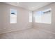 A bedroom with three windows and neutral carpeting provides ample natural light and a cozy feel at 12283 W 57Th Ln, Arvada, CO 80002