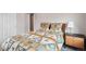 Bright bedroom featuring a cozy bed with a unique patterned quilt and a modern nightstand at 12283 W 57Th Ln, Arvada, CO 80002