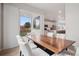Bright dining area featuring modern wood table and view to the backyard at 12283 W 57Th Ln, Arvada, CO 80002