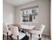 Formal dining room boasts a modern table with six chairs and a window with neighborhood views at 12283 W 57Th Ln, Arvada, CO 80002
