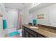 Well-lit bathroom includes a shower-tub combo, sleek vanity with countertop, and decorative accents at 12860 Jasmine St # C, Thornton, CO 80602