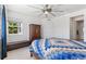 Bright bedroom with a large window, ceiling fan, and wood-frame bed with a colorful patchwork quilt at 12860 Jasmine St # C, Thornton, CO 80602