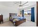 Comfortable bedroom with a large window, ceiling fan, and wood-frame bed with a colorful patchwork quilt at 12860 Jasmine St # C, Thornton, CO 80602