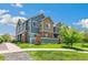 Charming two-story townhome with stone accents, manicured lawn, green landscaping, and inviting walkway at 12860 Jasmine St # C, Thornton, CO 80602