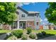 Inviting townhome showcasing stone accents, lush landscaping, and a charming covered entrance, bathed in natural light at 12860 Jasmine St # C, Thornton, CO 80602