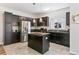 Modern kitchen with stainless steel appliances, a center island, and dark cabinetry for a sleek, functional design at 12860 Jasmine St # C, Thornton, CO 80602