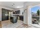Contemporary kitchen with a center island, dark cabinets, and sliding door access to a deck for outdoor dining at 12860 Jasmine St # C, Thornton, CO 80602