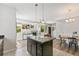 Open kitchen featuring a center island, dark cabinetry, and seamless flow into the adjacent dining and living areas at 12860 Jasmine St # C, Thornton, CO 80602