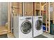 Unfinished basement area features a modern side-by-side washer and dryer set, ready for your laundry needs at 12860 Jasmine St # C, Thornton, CO 80602