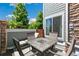 Comfortable patio with stone dining table, seating, privacy fence, and sliding glass door access to the home at 12860 Jasmine St # C, Thornton, CO 80602