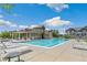 Community pool and clubhouse featuring lounge chairs, tables, and well-maintained landscaping at 12860 Jasmine St # C, Thornton, CO 80602