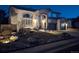 Home exterior at night features well-lit landscaping, a driveway, and a two-car garage at 10472 Grizzly Gulch, Highlands Ranch, CO 80129