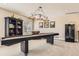 Carpeted game room with large black bookcase, shuffleboard, and beverage cooler at 10472 Grizzly Gulch, Highlands Ranch, CO 80129